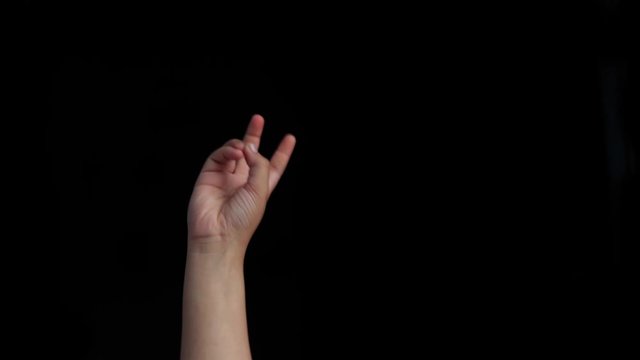 Single human hand coming up and showing bye-bye sign isolated on black.