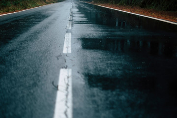 Concept of travel on a wet danger asphalt road in winter or under hurricane or storm weather - climate change and cold season concept
