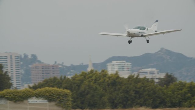 Small generic private propeller airplane preparing for landing, no tail or identification number. 60 FPS Slow Motion, 4K RAW graded footage