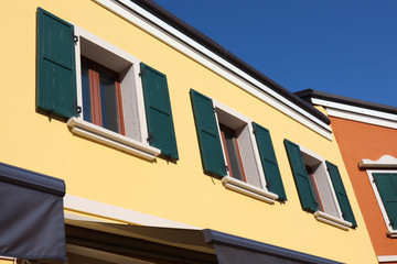 detail of the colorful yellow house with window on clear sunny day and blue sky in touristic place San Marino, Italy