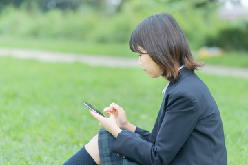 スマホを触る女子高生