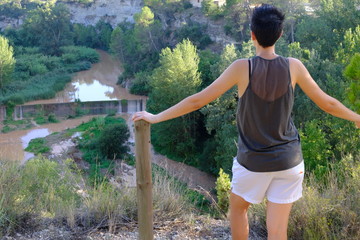 Girl watching the landscape from a cliff