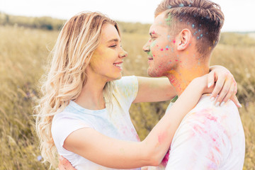 attractive woman and handsome man smiling and hugging outside