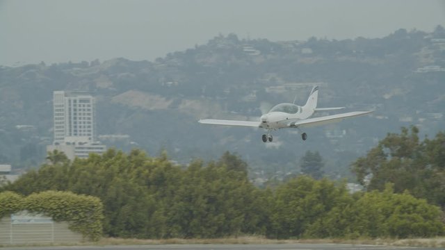 Small generic private propeller airplane preparing for landing, no tail or identification number. 60 FPS Slow Motion, 4K RAW graded footage