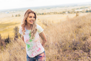 attractive woman in t-shirt smiling and looking away outside