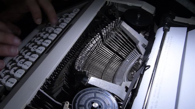 Typing in a old qwerty typewriter with white keys with sound