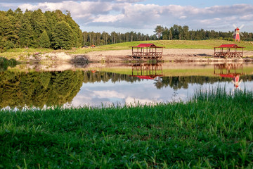 Rest zone. Blue water in a forest lake with pine trees. The forest is reflected in the water.