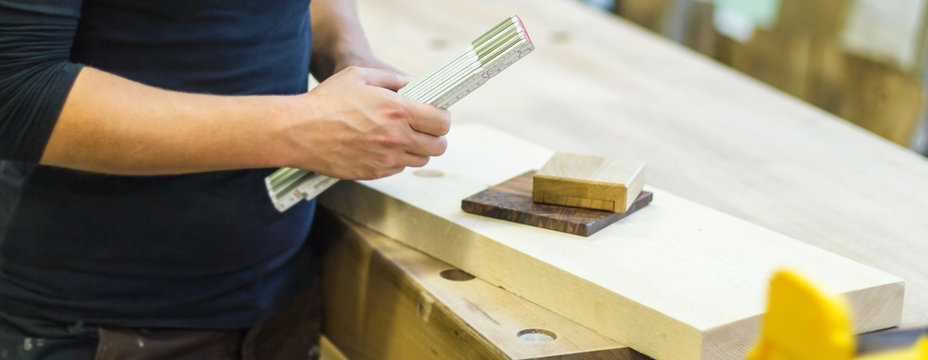 Tischlerin Tischler mit Ma&szlig;stab Meterstab Zollstock und Holzmustern Materialmustern in der Werkstatt