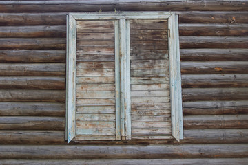 Old house with boarded up window. Boarded-up windows of an old building, Old abandoned wooden house with broken windows. Old wooden window on the wooden wall. The concept of an abandoned house.