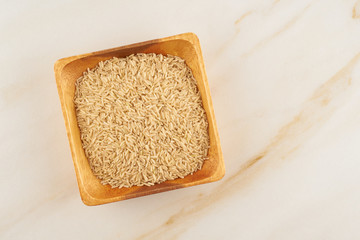brown rice in wooden bowl on marble, gluten free wholegrain, fodmap diet