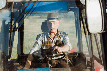 Fototapeta na wymiar selective focus of senior self-employed man driving tractor