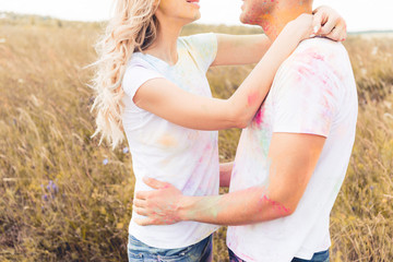 cropped view of blonde woman and man hugging outside