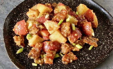 German potato salad with fried bacon and mustard dressing. traditional for oktoberfest festival.