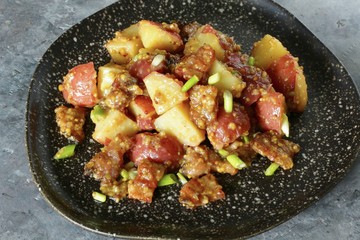 German potato salad with fried bacon and mustard dressing. traditional for oktoberfest festival.