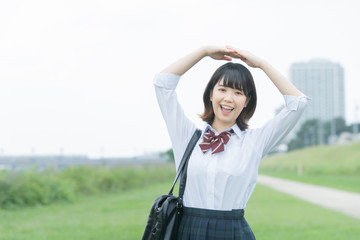 手で「マル」を作る女子高生