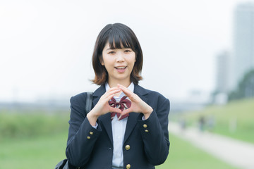 手で「マル」を作る女子高生