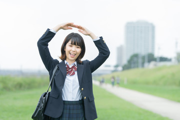 手で「マル」を作る女子高生