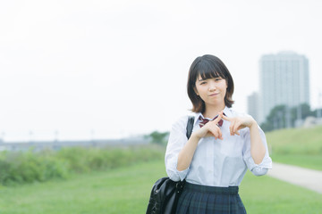 手で「バツ」を作る女子高生