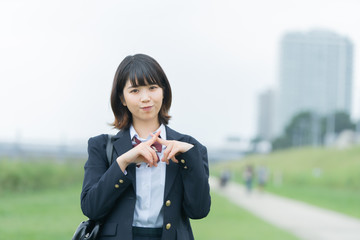手で「バツ」を作る女子高生
