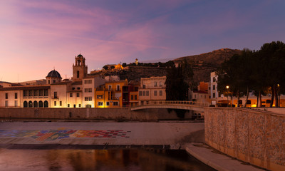 Fototapeta premium Evening mood in the southern Spanish city of Orihuela. On the mountain you can see the monastery, below a church and the river Segura, which flows through the city.