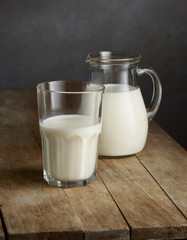 milk jug and glass on wooden table