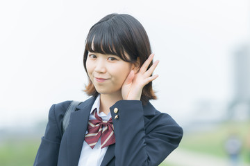 耳を傾ける女子高生