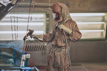 employee body painting workshop carries out painting of the internal elements of the car.
