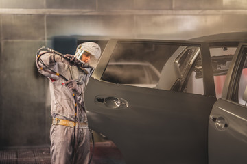 employee body painting workshop carries out painting of the internal elements of the car.