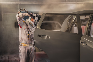 employee body painting workshop carries out painting of the internal elements of the car.