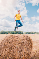 Naklejka na ściany i meble Caucasian Irish boy 11 years old in free flight while jumping against a blue summer sky