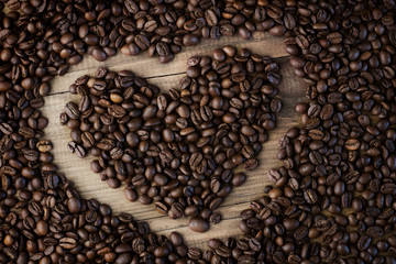 Coffee beans background. Organic coffee. Coffee beans on a wooden background in the form of a heart
