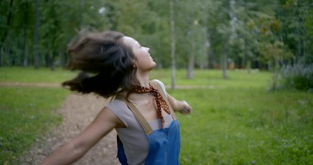 smiling brunette with long loose hair shakes head and jumps