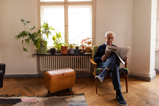 Senior Man Reading Newspaper At Home