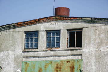 an abandoned building with broken Windows and rusty gates.