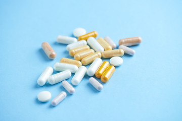 Vitamins and supplements on bright paper background. Concept for a healthy dietary supplementation. Close up. Copy space. 