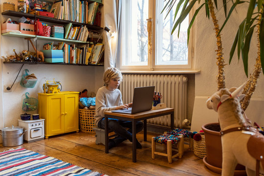 Boy Using Laptop In His Room At Home