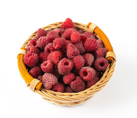 Ripe raspberries in a wicker plate on a white background