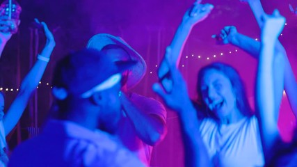 Excited young people enjoying party music dancing off celebrating summer holidays together at night.