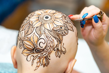 Drawing process of henna mehndi ornament on womans head