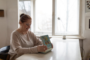 Senior woman looking in jewelry box at home