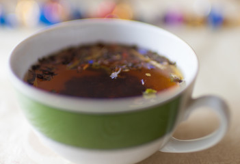 Cup of black flower tea on the table, closeup, selective focus