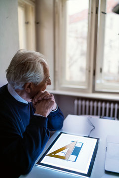 Senior man using tablet with architectural plan