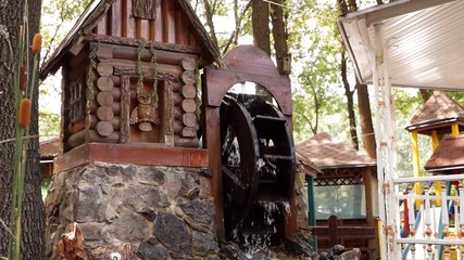 A wooden wheel produces energy using the power of water an old traditional mechanism. Wooden ring rotates with the power of water