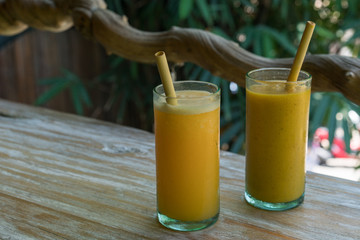 Zero waste concept with reuse bomboo straw, tropical delicious juice, Thai Bali seasonal, cool ice beverage for refreshing in summer on green nature bokeh background