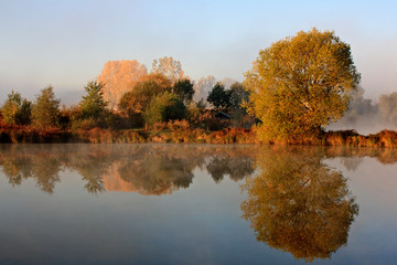 landscape with morning mist by the lake in the fall