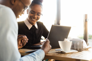 Black  African American coworkers doing digital teamwork arround a coffee cup