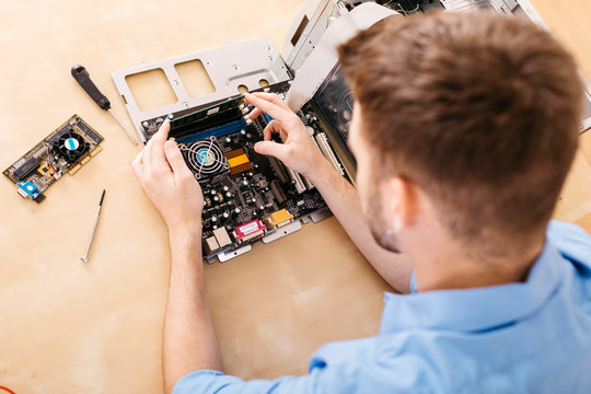 Technician repairing a desktop computer, changing the computer's RAM