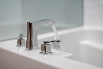 Closeup of bathroom faucet on white tub
