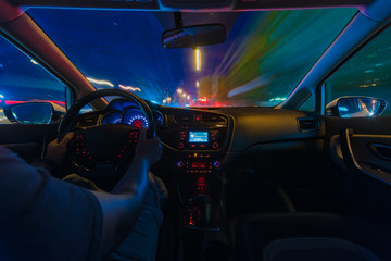 Night road view from inside car natural light street and other cars is motion blurred