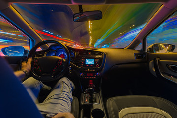 Night road view from inside car natural light street and other cars is motion blurred